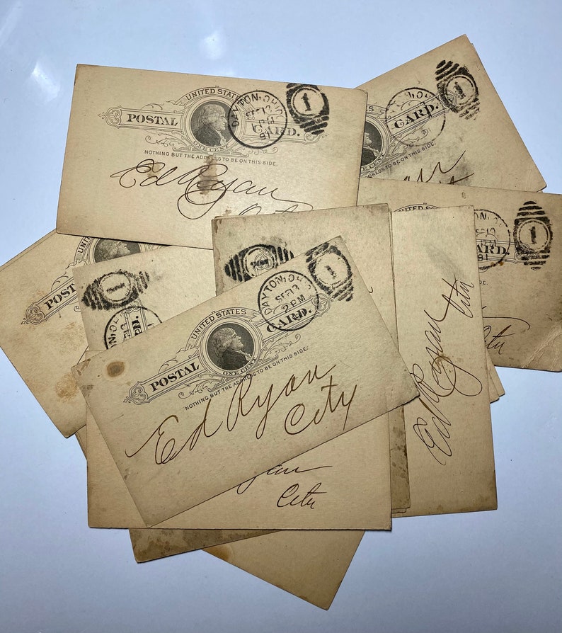 May include: A collection of antique postal cards. The cards are beige with black ink stamps and handwritten script. Each card features a portrait of a man and the words "United States Postal" and "Card".
