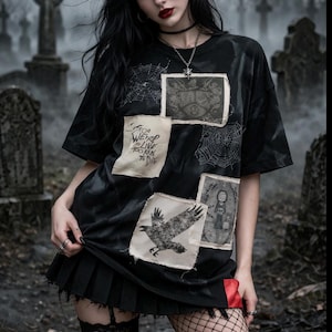 May include: Black t-shirt with patches featuring a raven, spiderwebs, and gothic imagery. The shirt has the text "Too Weird to Live, Too Rare to Die". The model is wearing a black pleated skirt and fishnet stockings.