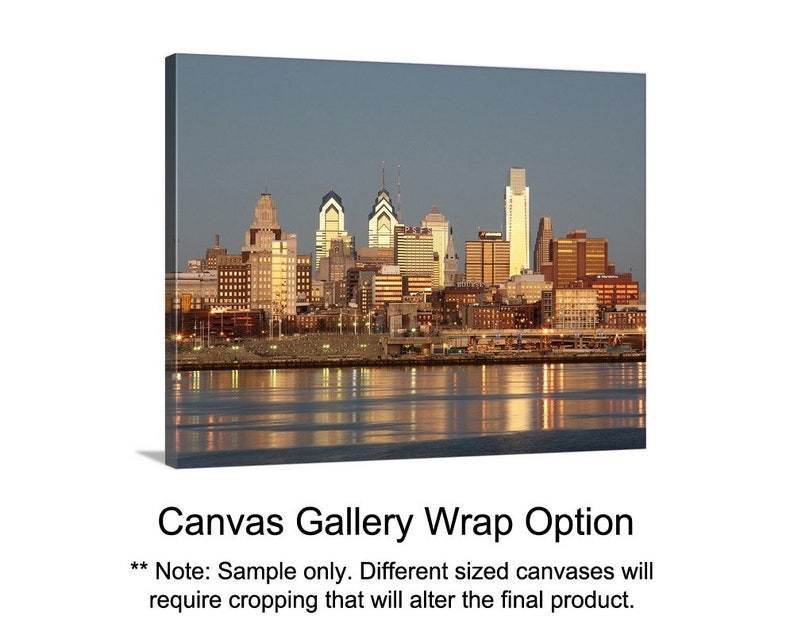 May include: A panoramic view of a city skyline at dusk. The city is lit up with lights, and the buildings are reflected in the water. The sky is a soft blue, and the water is a dark blue. The image is a sample for a canvas gallery wrap option.