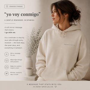 Könnte beinhalten: Cremefarbener Kapuzenpullover mit Fronttasche und Kordelzug. Auf der Vorderseite ist der Text "ogimnos voy oy" aufgedruckt. Das Bild enthält spanischen Text, "yo voy conmigo", was "Ich gehe mit mir" bedeutet.