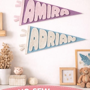 May include: Two felt pennant flags with the names "Amira" and "Adrian" in white letters. The "Amira" flag is purple, and the "Adrian" flag is light blue. The words "PDF PATTERN" and "NO-SEW NAME FLAGS" are also visible.