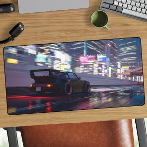 Può includere: Tappetino per mouse nero con un'auto sportiva nera che sfreccia in una città di notte. L'auto ha una grande ala posteriore e dettagli rossi. Lo sfondo mostra luci e edifici sfocati della città.
