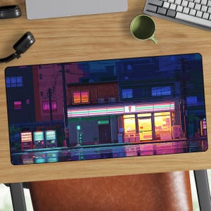 May include: A rectangular desk mat featuring a pixel art illustration of a convenience store at night. The scene displays a brightly lit storefront with the number 7 logo, vending machines on the left, and reflections on the wet ground.