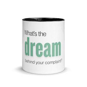 May include: A white ceramic mug with a black handle and the text "But First, Coffee" in a black, bold font. The mug is sitting on a white surface. The mug is approximately 4 inches tall.