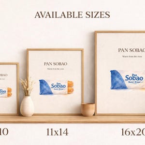 Puede incluir: Tres impresiones enmarcadas de pan dulce "Pan Sobao", en tama&ntilde;os de 20x25, 28x36 y 41x51 cm. Cada impresi&oacute;n presenta una ilustraci&oacute;n en acuarela del pan en un paquete azul y blanco, con el texto "Pan Sobao" y "Sweet Bread."