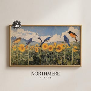 Può includere: Una stampa incorniciata raffigurante un campo di girasoli con diversi uccelli appollaiati sui fiori. Il cielo è blu con nuvole bianche. La stampa ha una cornice dorata e il testo "NORTHMERE PRINTS" in basso.