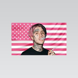 Könnte beinhalten: Porträt einer Person mit rosa Haaren und Gesichtstätowierungen, die eine Zigarette raucht. Der Hintergrund ist eine rosa und weiße amerikanische Flagge.