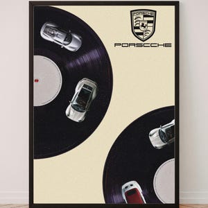 May include: A framed poster featuring two black vinyl records on a cream background. Three silver sports cars are positioned on the records. The top right corner displays the Porsche crest and the text PORSCHE in black capital letters.