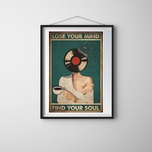 May include: Framed art print featuring a person with a vinyl record in place of a head, holding a coffee cup. The text "LOSE YOUR MIND" and "FIND YOUR SOUL" are displayed above and below the central image, respectively. The artwork has a vintage aesthetic.