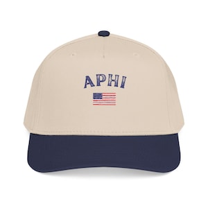 May include: A baseball cap with a cream-colored crown and a navy blue brim. The cap features the word "APHI" in blue letters above a small American flag.