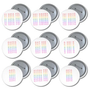 Könnte beinhalten: Eine Sammlung von neun runden, weißen Ansteckbuttons, die jeweils den Namen einer Studentenverbindung in einer vertikalen, regenbogenfarbenen Schriftart zeigen. Die Namen umfassen Pi Beta Phi, Chi Omega, Tri Delta, Kappa, Kay Dee, A Chi O, Adpi, Alpha Phi und Zeta.