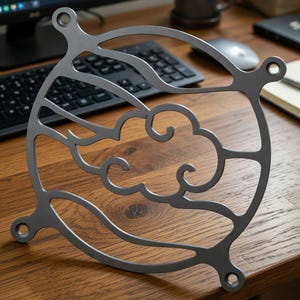May include: A gray metal fan grill with a decorative cloud design. The grill has a circular shape with four mounting holes and a stylized cloud pattern cut into the metal. The fan grill is designed to protect the fan blades.