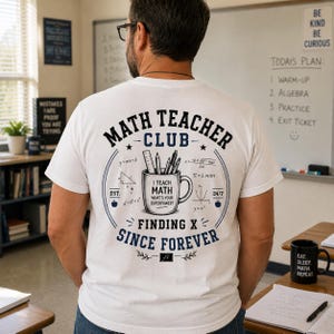 Könnte beinhalten: Ein weißes T-Shirt mit einem Rückendruck, der den Text "MATH TEACHER CLUB" und "FINDING X SINCE FOREVER" zeigt. Das Design enthält eine mittige Tasse mit Stiften und Bleistiften, umgeben von mathematischen Formeln, Symbolen und Äpfeln.
