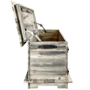 May include: A weathered wooden storage chest with a hinged lid, open to reveal the interior. The chest is made from grey wood with visible grain and features a metal handle and hinges. The lid is supported by a metal mechanism.