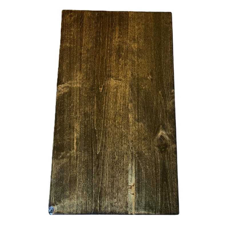 May include: A rectangular wooden board with a dark brown stain. The wood grain is visible, with lighter streaks and knots adding texture. The board is likely for crafting or home decor.