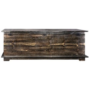 May include: A large, rustic wooden chest with a hinged lid. The chest is made of dark brown wood with visible grain and knots, and features metal hardware. The chest sits on a low base and has a rectangular shape, perfect for storage.