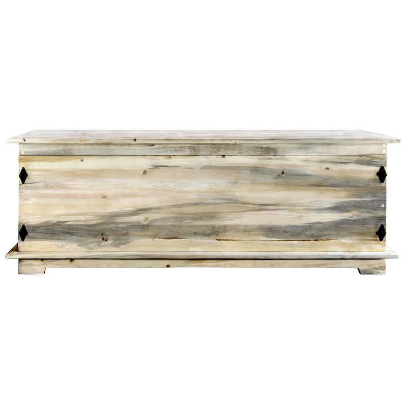 May include: A large, rectangular wooden storage chest with a light, weathered finish. The chest features a hinged lid, decorative black metal accents, and sits on a low base. The wood grain is visible, adding to its rustic charm. Suitable for storing blankets or other items.