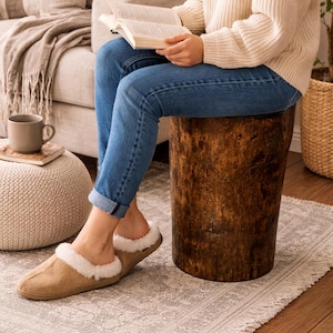 Puede incluir: Un par de pantuflas de gamuza color canela con forro y ribete de piel sint&eacute;tica blanca. Las pantuflas tienen un dise&ntilde;o de punta redondeada y un estilo sin cordones, lo que proporciona una apariencia suave y texturizada. El exterior es marr&oacute;n claro.
