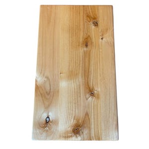 May include: A rectangular wooden board with a light brown color and visible wood grain. The board has several knots and a smooth, polished surface. The edges are slightly rounded.