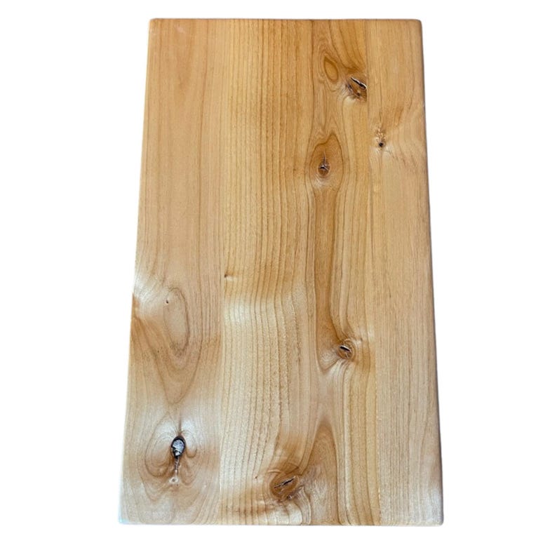 May include: A rectangular wooden board with a light brown color and visible wood grain. The board has several knots and a smooth, polished surface. The edges are slightly rounded.