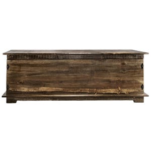 May include: A large, rectangular wooden chest with a distressed finish. The chest is made of dark brown wood with visible grain and knots. It features a flat top, a base, and decorative metal accents on the front. The chest is approximately 152 cm long.
