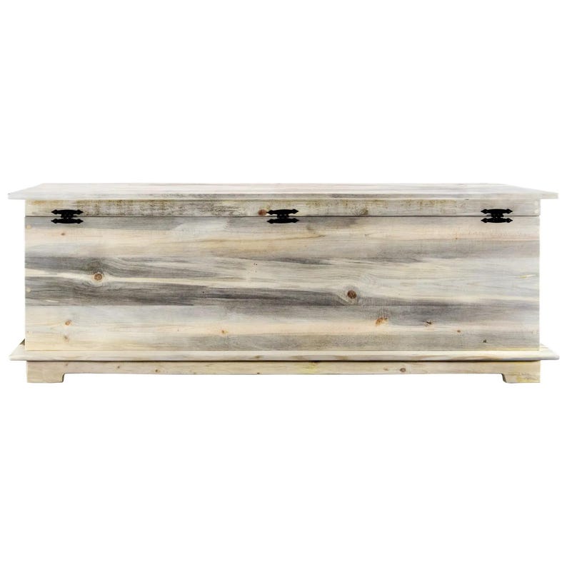 May include: A large, rectangular wooden storage chest with a light, weathered finish. The chest features black metal hinges and a simple, rustic design. The chest is elevated on a low base.