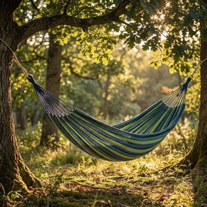 May include: A striped hammock in shades of green and blue is suspended between two trees in a sunlit forest. The hammock is made of woven fabric and is designed for relaxation and outdoor leisure.