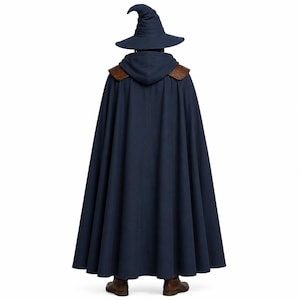 May include: A dark blue hooded cloak with brown leather-like shoulder accents, worn with a matching dark blue pointed wizard hat. The floor-length garment features a pleated design and is paired with brown boots, viewed from the back.
