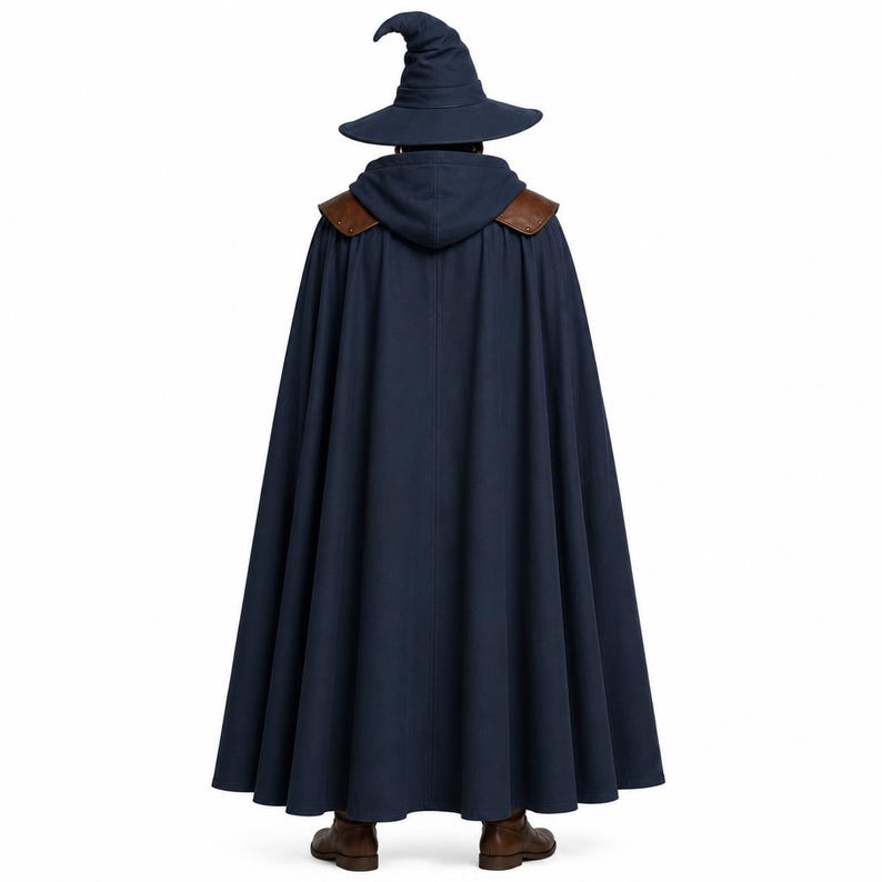 May include: A dark blue hooded cloak with brown leather-like shoulder accents, worn with a matching dark blue pointed wizard hat. The floor-length garment features a pleated design and is paired with brown boots, viewed from the back.