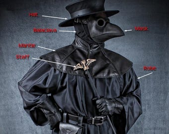 Puede incluir: Un disfraz de médico de la peste negro, con sombrero, máscara, pasamontañas, capa, túnica, guantes, bolsa y bastón. La máscara tiene aberturas redondas para los ojos. El disfraz incluye un cinturón y un emblema decorativo. El texto "TOM BANWELL DESIGNS" está arriba.