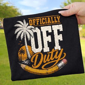 Könnte beinhalten: Schwarzes T-Shirt mit dem Text "OFFICIALLY OFF Duty" in Weiß und Orange. Das Design umfasst eine Palme, einen Sonnenuntergang und einen Bleistift. Das T-Shirt wird von einer Hand gehalten.