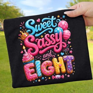 Könnte beinhalten: Schwarzes T-Shirt mit dem Schriftzug "Sweet, Sassy, and Eight" in einem farbenfrohen, verspielten Design. Das Design beinhaltet einen Cupcake, Luftballons und Sterne, ideal für den achten Geburtstag.