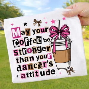 Könnte beinhalten: Weißes Stoffquadrat mit dem Text "May your coffee be stronger than your dancer's attitude" im Collage-Stil. Rechts befindet sich eine Kaffeetasse mit einer rosa Schleife. Rosa Sterne und eine Schleife mit Leopardenmuster vervollständigen das Design.