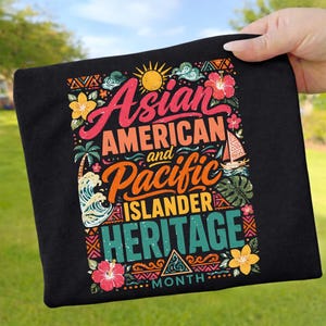 Könnte beinhalten: Schwarzes T-Shirt mit farbenfrohem Grafikdesign. Das Design zeigt den Text "Asian American and Pacific Islander Heritage Month" in verschiedenen Schriftarten und Farben sowie florale und tropische Elemente.