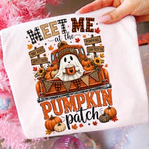Könnte beinhalten: Ein weißes T-Shirt mit einer Grafik eines Geistes, der eine Mütze trägt und eine Tasse hält, sitzend in einem orangefarbenen Pickup. Der Text lautet MEET ME at the PUMPKIN patch, mit Schildern für HAY RIDES, APPLE CIDER, PUMPKINS und FARM FRESH FUN.