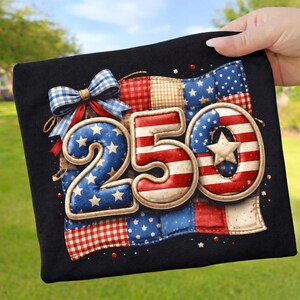 Könnte beinhalten: Schwarzes T-Shirt mit einem patriotischen "250"-Design in Rot, Weiß und Blau. Das Design umfasst einen Patchwork-Hintergrund mit Sternen und Streifen sowie eine blau-weiße Schleife. Das Design erinnert an die amerikanische Flagge.