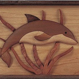 May include: A wooden carving of a dolphin jumping out of the water, surrounded by brown seaweed. The dolphin is made of light and dark wood, creating a 3D effect.