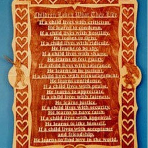 Puede incluir: Una placa de madera con un marco en forma de corazón y un poema sobre la importancia del amor y la aceptación. El poema dice: "Si un niño vive con críticas, aprende a condenar. Si un niño vive con hostilidad, aprende a luchar. Si un niño vive con el ridículo, aprende a ser tímido. Si un niño vive con la vergüenza, aprende a sentirse culpable. Si un niño vive con tolerancia, aprende a ser paciente. Si un niño vive con aliento, aprende confianza. Si un niño vive con elogios, aprende a apreciar. Si un niño vive con justicia, aprende justicia. Si un niño vive con seguridad, aprende a tener fe. Si un niño vive con aprobación, aprende a gustarse a sí mismo. Si un niño vive con aceptación y amistad, aprende a encontrar el amor en el mundo."