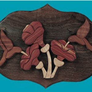 May include: Intricately carved wooden wall art featuring three hummingbirds in flight, each with detailed wings and a long beak, hovering around three red and brown flowers with green stems. The artwork is set against a dark wood background.