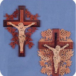 May include: Two wooden crucifixes with detailed carvings. One has a dark brown cross with a light-coloured Jesus figure and decorative leaf accents. The other has a similar design, with a lighter wood tone and intricate floral patterns.