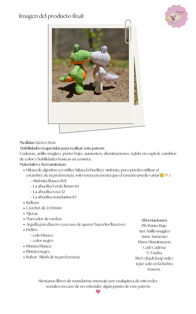 Puede incluir: Dos peque&ntilde;as figuras de dinosaurios tejidas a crochet, una verde con detalles naranjas y otra blanca con detalles rosas, se encuentran frente a frente. Cada figura tiene una argolla met&aacute;lica para llavero en la cabeza. Miden 12 cm por 9 cm.