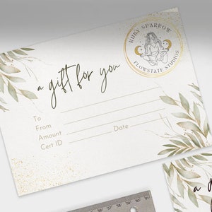 May include: A white gift certificate with a gold circle logo that says "Ruby Sparrow Flowstate Studios". The logo features a woman sitting in a yoga pose with a crescent moon on each side of her. The text "a gift for you" is written in cursive at the top of the certificate. The certificate has lines for "To", "From", "Amount", "Cert ID", and "Date".