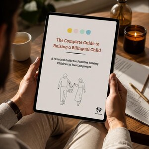 Peut inclure: Une tablette numérique affichant la couverture d'un livre intitulée The Complete Guide to Raising a Bilingual Child, avec le sous-titre A Practical Guide for Families Raising Children in Two Languages, illustrée par un dessin au trait d'une famille.