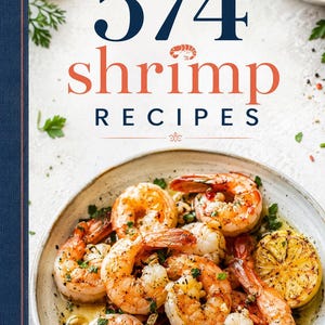 Puede incluir: Portada de libro de cocina con el título "574 Shrimp Recipes" en azul marino y coral. En primer plano, un plato de gambas cocinadas con gajos de limón y hierbas. La imagen tiene una estética brillante y acogedora.