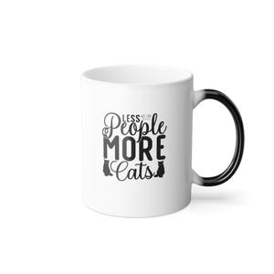 Puede incluir: Taza de cerámica blanca con asa e interior negros. La taza muestra el texto "Less People More Cats" en negro, con dos siluetas de gatos negros. Un regalo divertido para los amantes de los gatos.