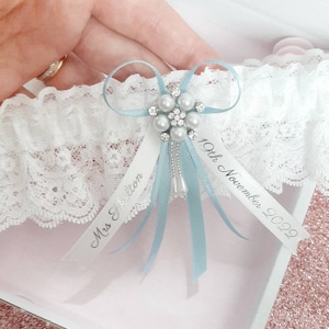 Blue personalised wedding garter with pearl centre, light blue bridal garter with name and date, personalised ribbons, something blue