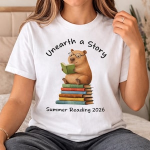 Bonita camiseta de lectura de capibara: "Descubre una historia", ideal para leer en verano (2026), ideal como regalo para amantes de los libros, para hombres, mujeres y niños.