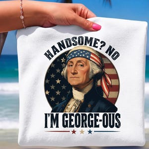 Puede incluir: Una camiseta blanca con un gráfico de George Washington usando un pañuelo de estrellas y rayas. El texto "HANDSOME? NO I'M GEORGE-OUS" aparece en letras negras negritas sobre un fondo circular con el diseño de la bandera estadounidense.