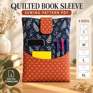 May include: A quilted book sleeve sewing pattern PDF featuring a navy blue fabric with a white fern and berry print, accented by an orange pocket with a white dash pattern. The sleeve includes a matching orange tab closure and four size options.