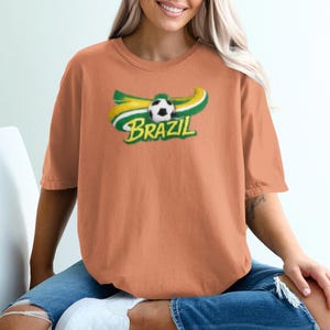 Orange t-shirt with Brazil and a soccer ball graphic.